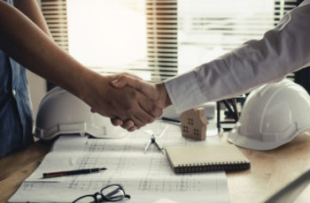 close up hand of construction worker team contractor hand shake after finishing up a business meeting to greeting start up project contract in construction site building, teamwork partnership concept